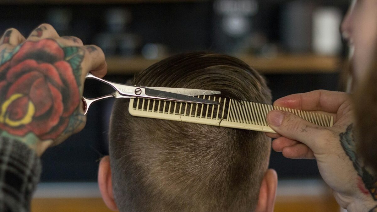 person holding white and gold hair comb