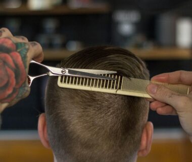 person holding white and gold hair comb